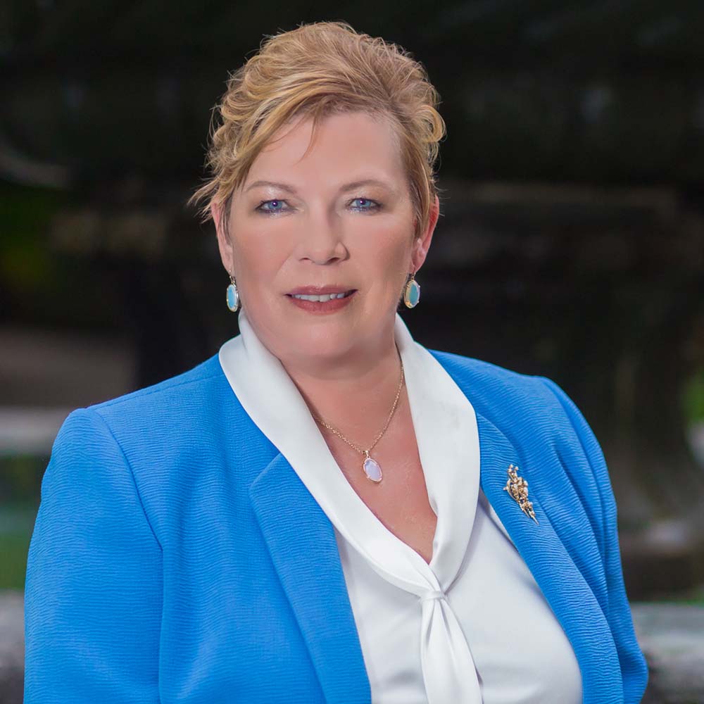 Professional woman in blue jacket outdoors.