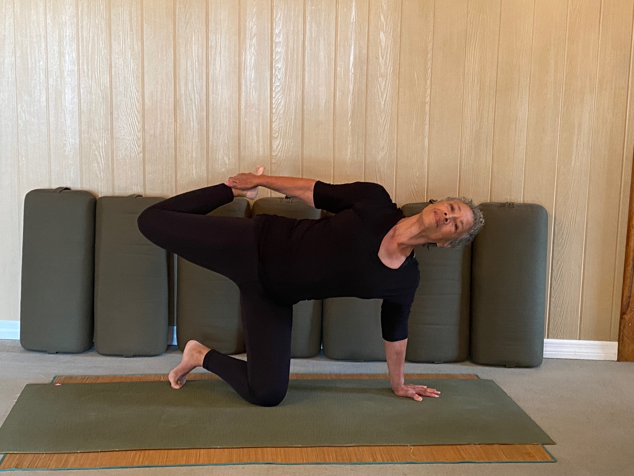 Woman practicing advanced yoga pose on mat.