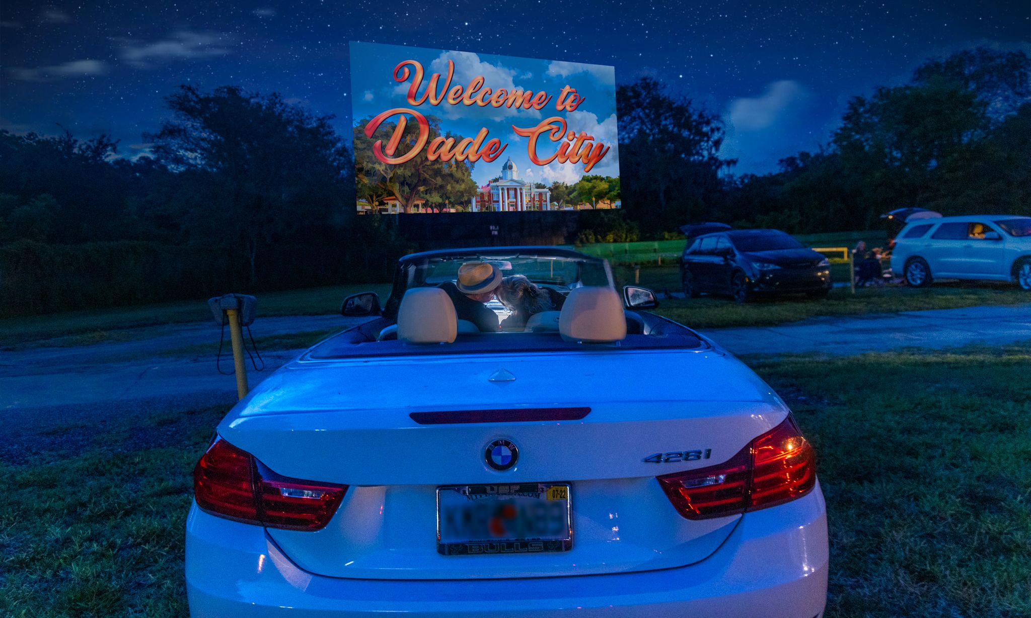 TCS-Jennifer-6 Drive-in theater evening with convertible car and welcome sign.