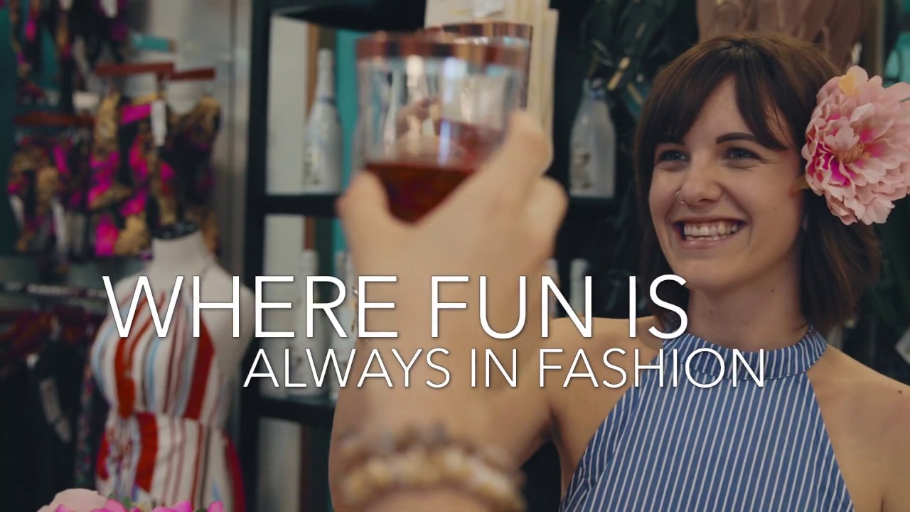 Smiling woman toasting in fashionable boutique.